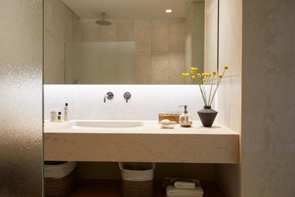 a bathroom with a sink and a mirror at Elix, Mar-Bella Collection in Perdika