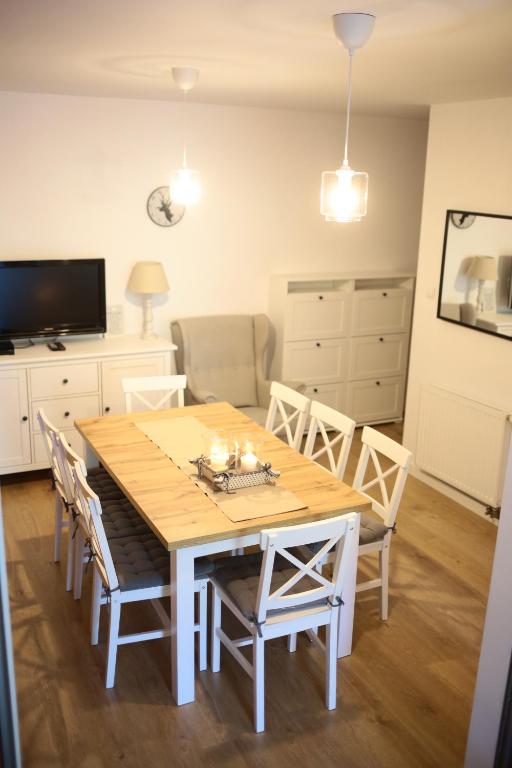 einen Esstisch mit Stühlen und einen TV in der Unterkunft Hulaj Dusza in Wisła