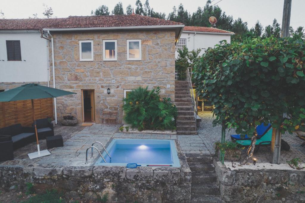 une maison avec une piscine en face de celle-ci dans l'établissement Quinta da Tia, à Baiões