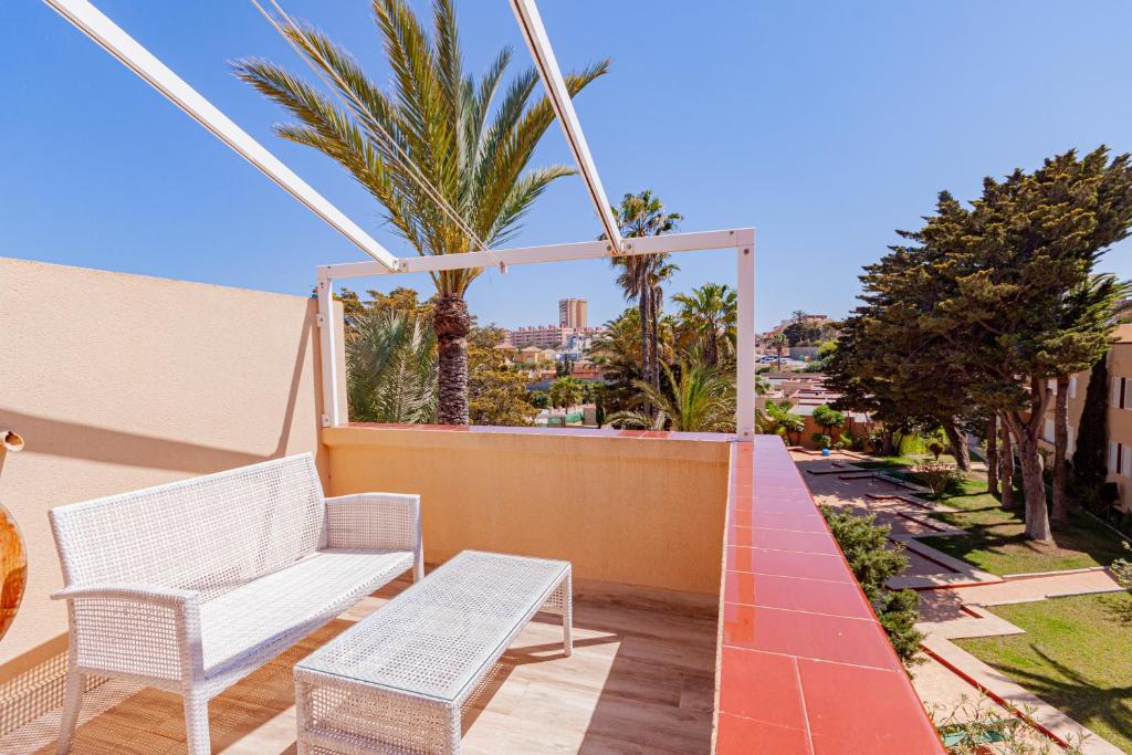 een balkon met 2 witte stoelen en palmbomen bij Alisios 312 in La Manga del Mar Menor