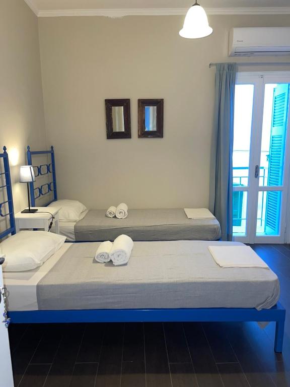 two beds sitting in a room with a window at AEGEAN VIEW SEASIDE ROOMS AND STUDIOS KEA in Korissia