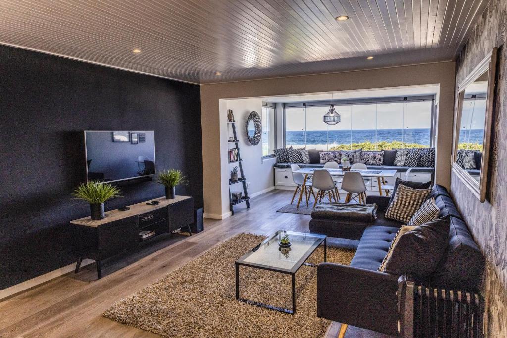 a living room with a couch and a tv at 67 Whale Rock Estate, Hermanus in Hermanus