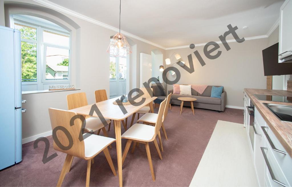 una cucina e una sala da pranzo con tavolo e sedie di Appartementhaus Zum Strandkorb a Kühlungsborn