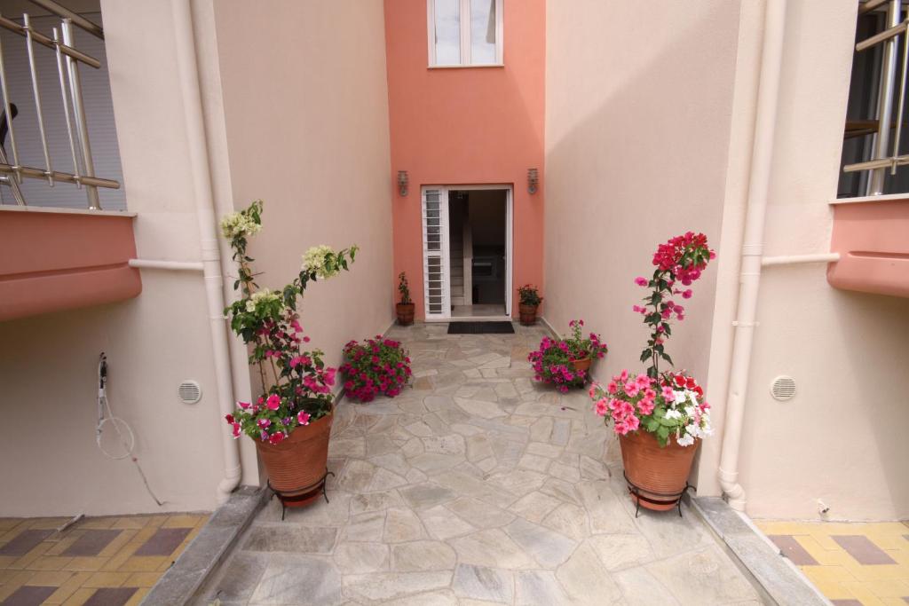 a courtyard with flowers in pots on a building at Coralli Studios in Ormos Panagias