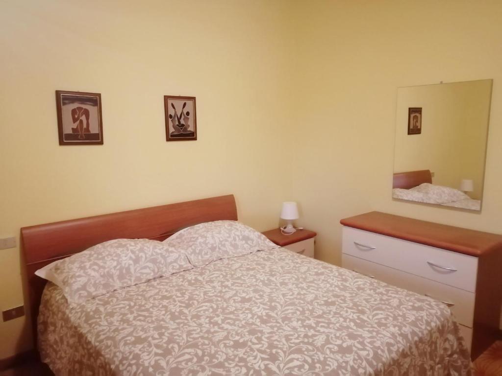 a bedroom with a bed and a dresser and a mirror at Elena Rooms in Campobasso