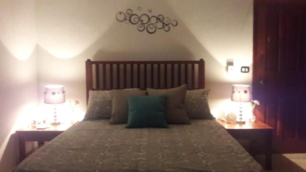 a bedroom with a large bed with two lamps at Private Apartments in Caribe Dominicus solo adultos in Bayahibe