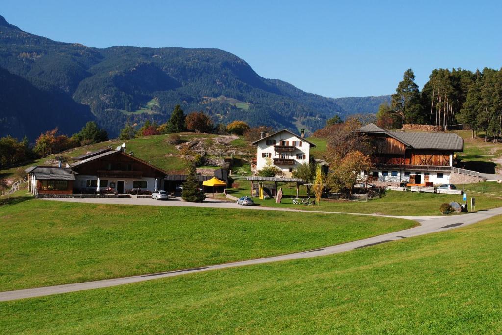 a house on a hill with mountains in the background at B&B Gasthaus Lieg in Castelrotto
