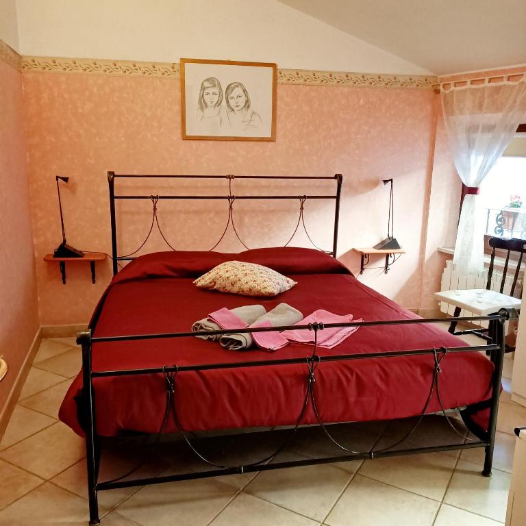 sypialnia z łóżkiem z czerwoną kołdrą w obiekcie B&B Brunamonti w mieście Arcevia