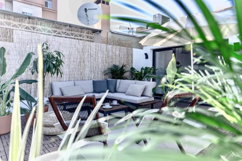 sala de estar con sofá y algunas plantas en Casa Mariel, en Málaga