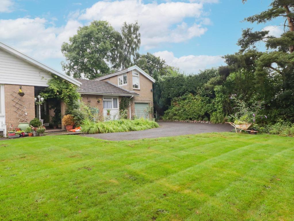 a house with a yard with a driveway at Beacons Rest in Llanspyddid