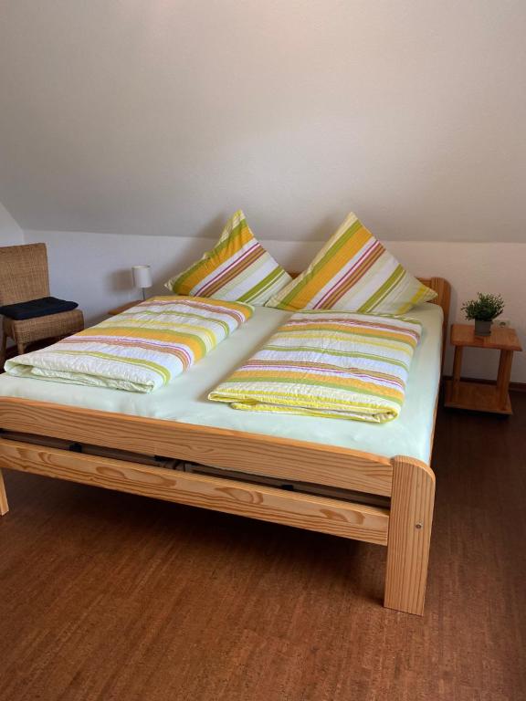 a bed with four pillows on it in a room at Wohnung auf dem Lande in Riepsdorf