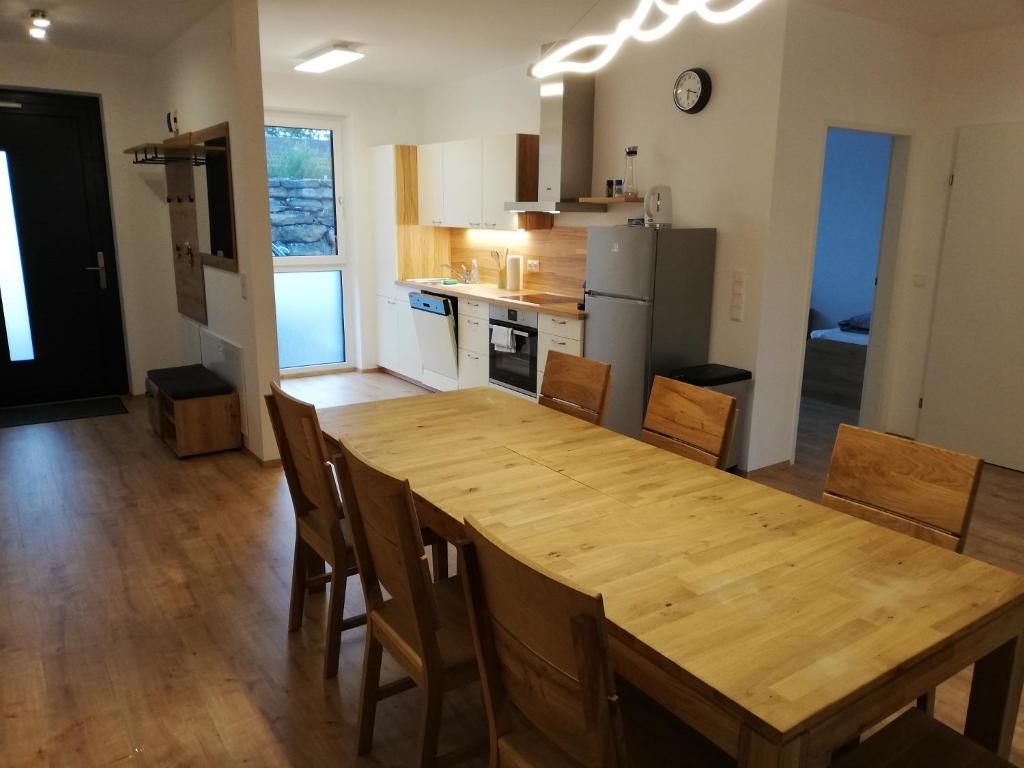 una cocina con una gran mesa de madera y sillas en Ferienbungalows Vital, en Lanzenkirchen