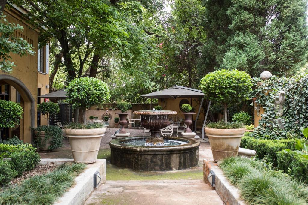 a garden with a fountain in the middle of a yard at Godiva Spa & Guesthouse in Groblersdal