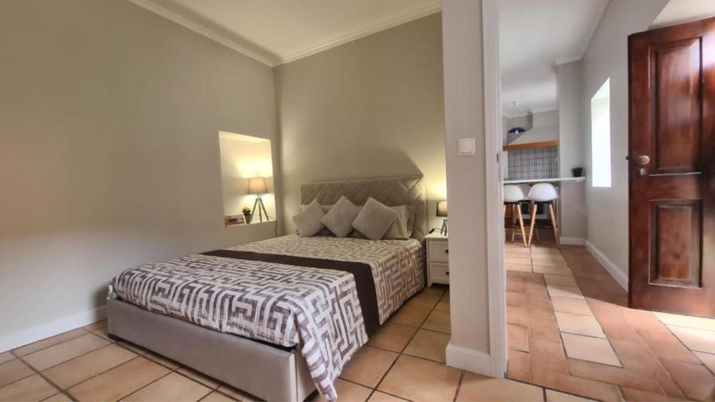 a bedroom with a large bed and a hallway at Casa da Avó Duca in Machico