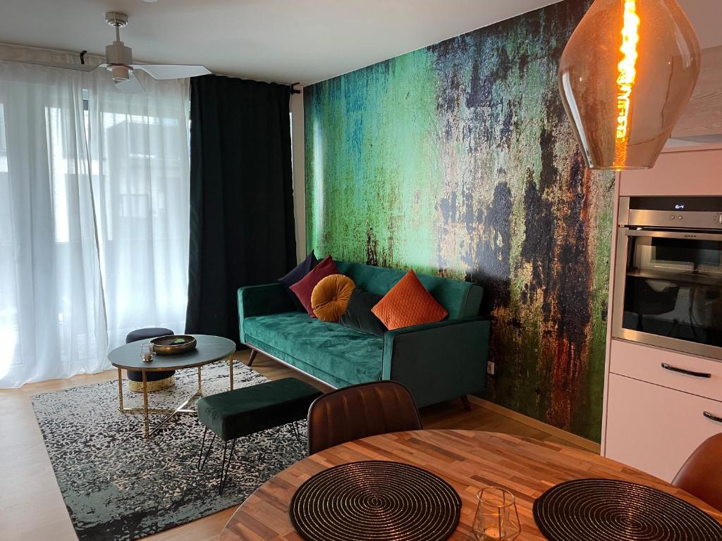 uma sala de estar com um sofá verde e uma mesa em Emerald Green Apartment em Offenbach
