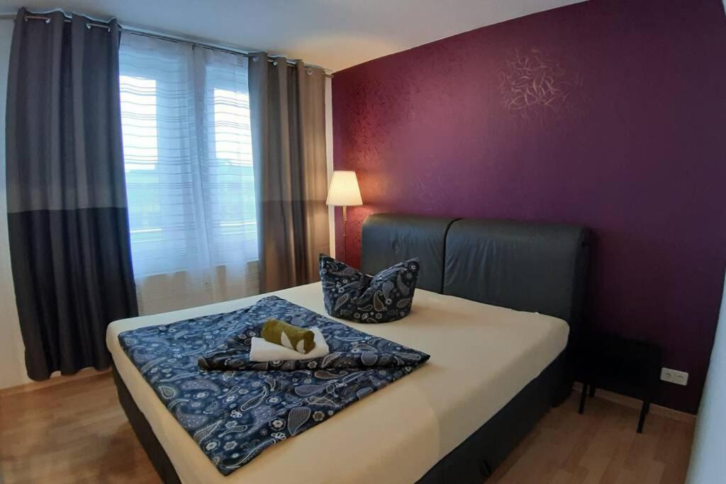 - une chambre dotée d'un lit avec un mur violet dans l'établissement LEA Apartments Luxus-3-Raum-Wohnung mit Tiefgarage, à Leipzig