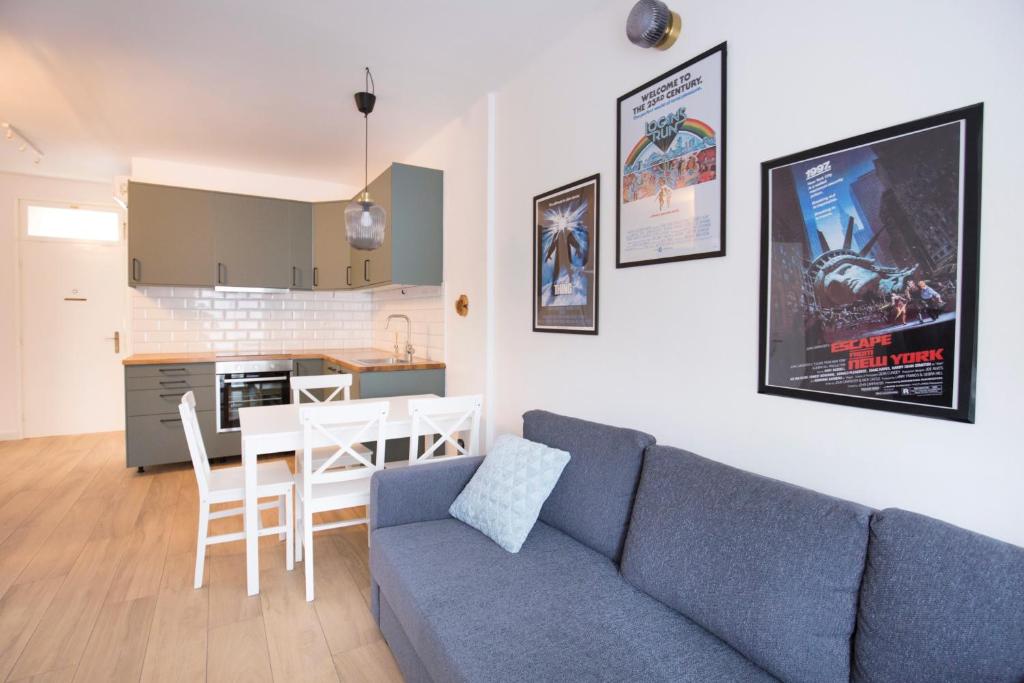 a living room with a blue couch and a kitchen at Firpo - Cozy two bedroom city centre apartment in Vis