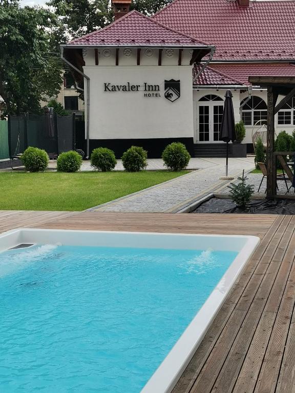 a swimming pool in front of a house at Kavaler inn hotel in Kuty