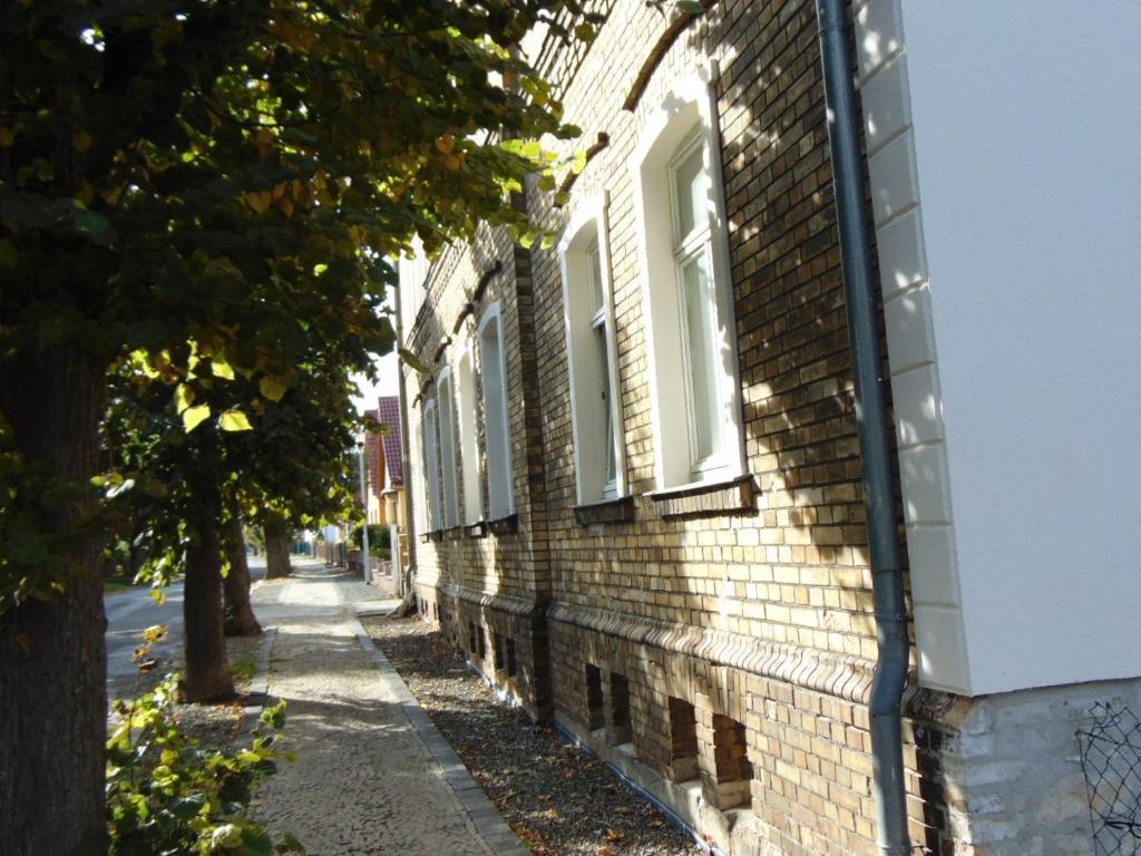 een bakstenen gebouw met witte ramen op een straat bij Hostel Ballenstedt in Ballenstedt