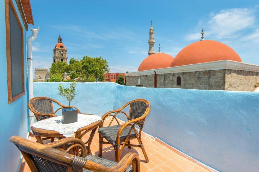 a patio with a table and chairs on a balcony at Old Town Roloi House in Rhodes Town