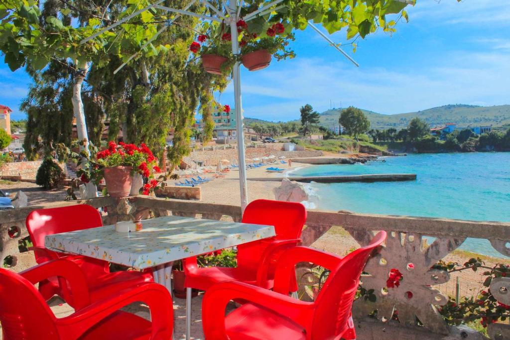 a table and chairs with a view of a beach at Mustafaraj Apartments Ksamil in Ksamil
