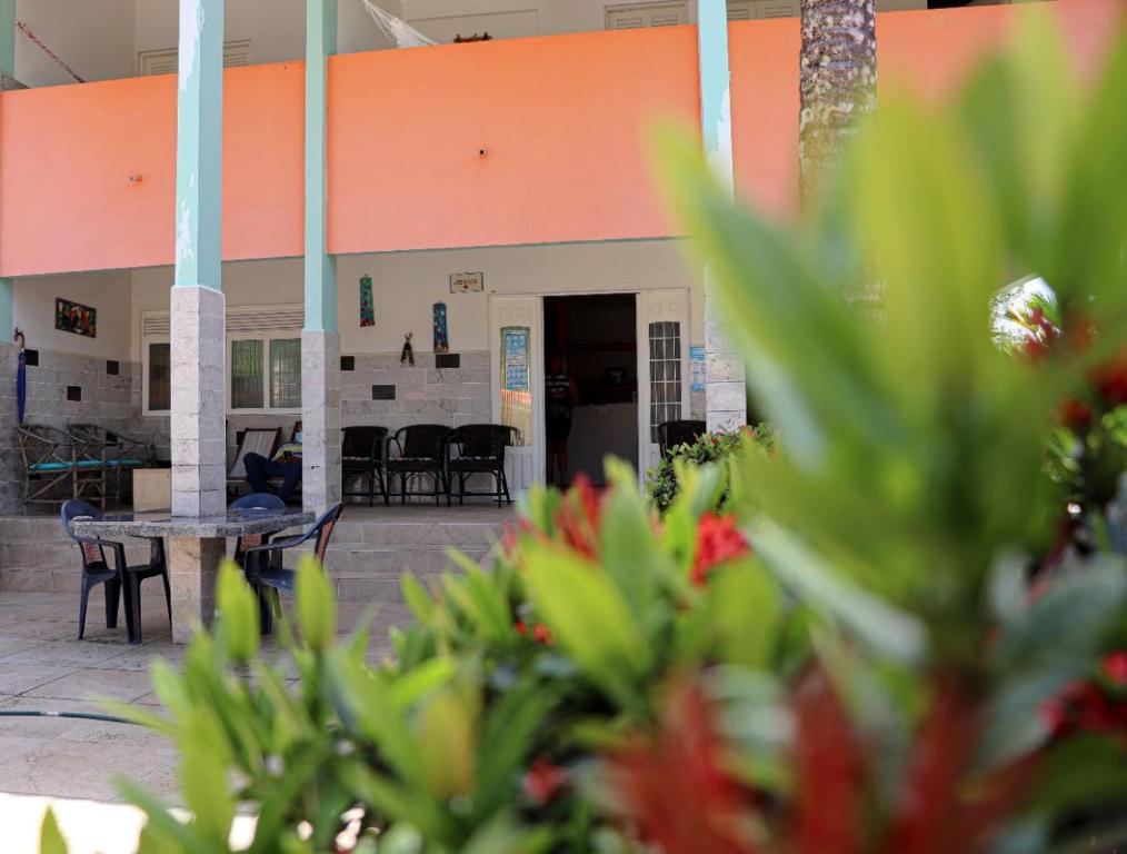 a building with a table and chairs in front of it at Pousada Marinah in São José da Coroa Grande