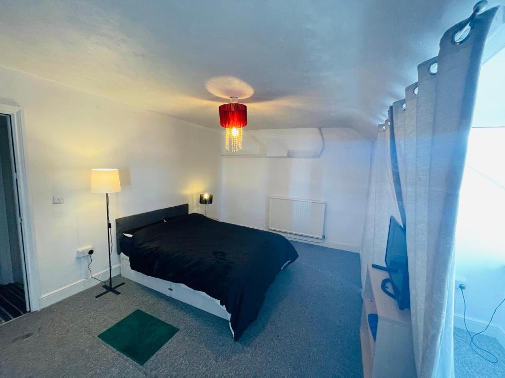 a bedroom with a black bed and a red light at Shouss guest house in Bristol