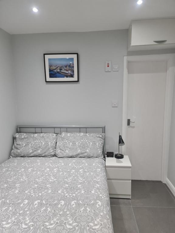 sypialnia z łóżkiem i zdjęciem na ścianie w obiekcie Cosy Lodge w mieście Thornton Heath