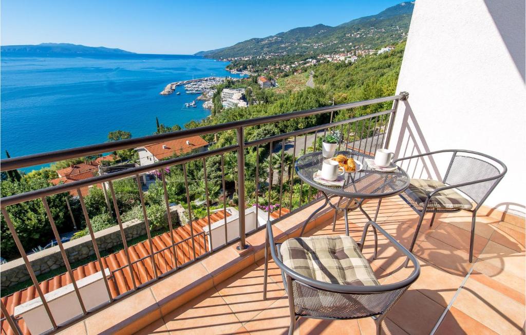 balcón con mesa, sillas y vistas al océano en 4 Bedroom Nice Apartment In Opatija, en Opatija