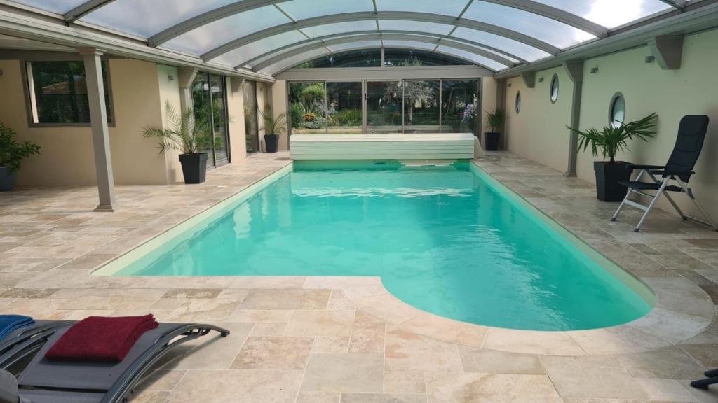 an indoor swimming pool with an arched ceiling and blue water at Maison de vacances Daumeray in Daumeray