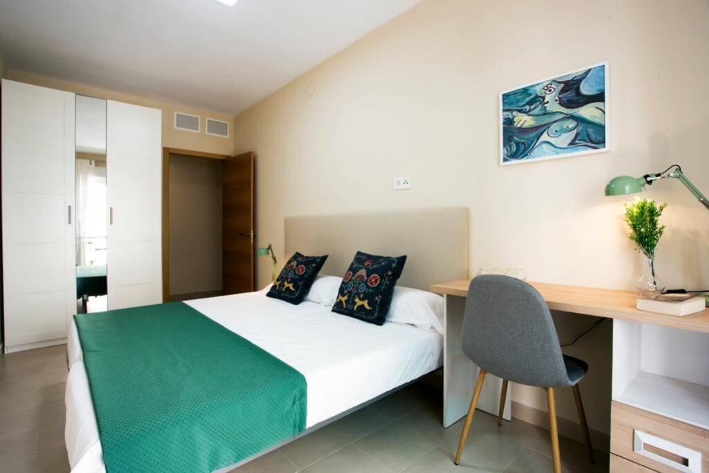 a bedroom with a bed and a desk and a desk at Sweet Apartment in Málaga
