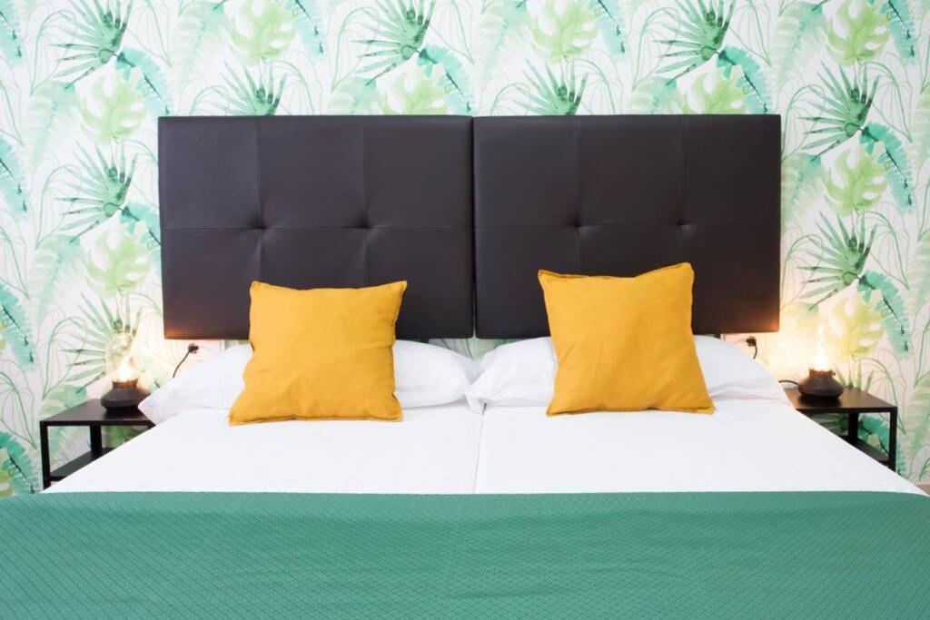 a bedroom with a large bed with yellow pillows at Sweet Apartment in Málaga