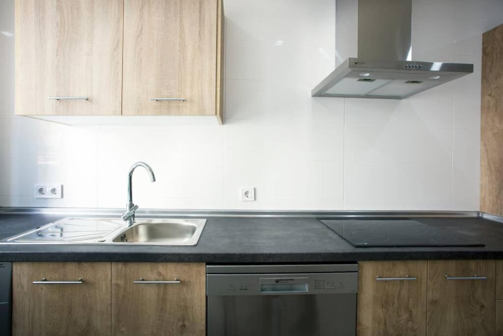 a kitchen with a sink and a stove at Sweet Apartment in Málaga