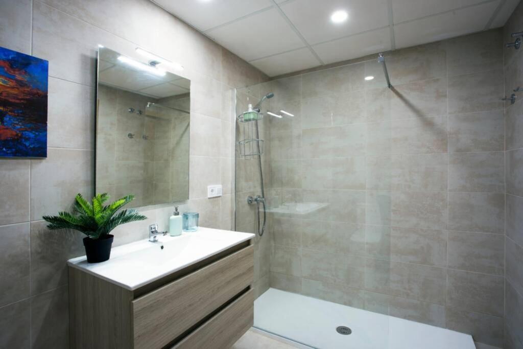 a bathroom with a shower and a sink and a mirror at Sweet Apartment in Málaga