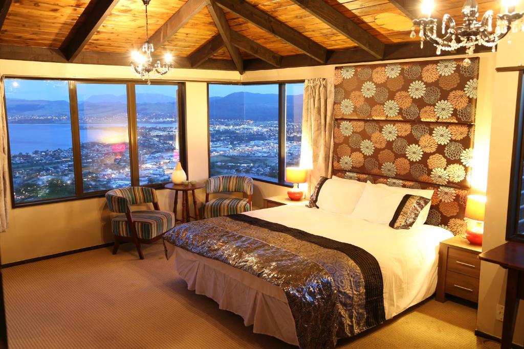 a bedroom with a bed with a view of a city at Aorangi Mountain Lodge in Rotorua
