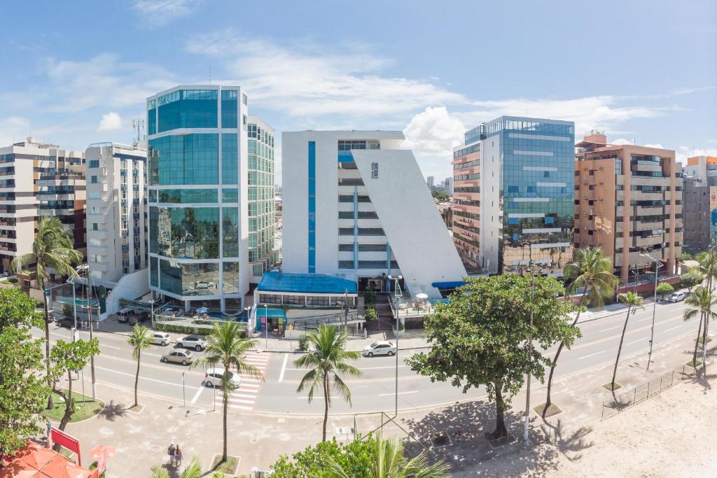 uma cidade com edifícios altos e uma rua com palmeiras em Praia Hotel Enseada em Maceió