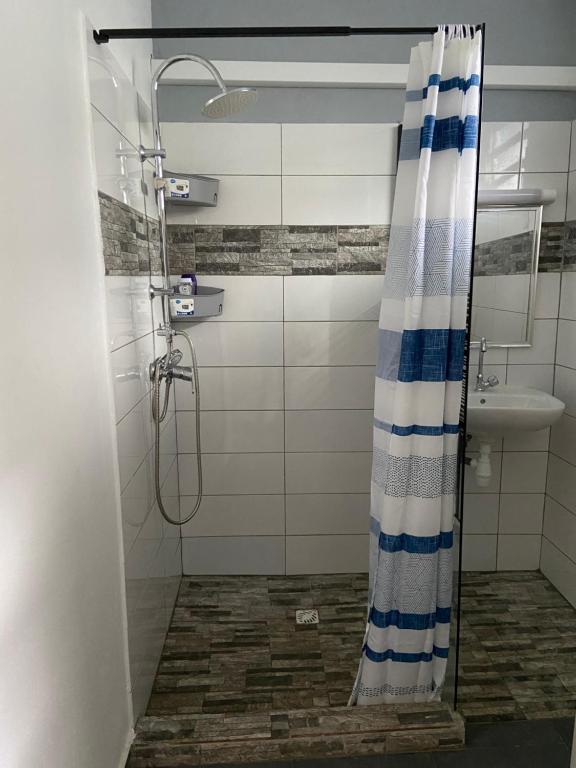 a shower with a blue and white shower curtain in a bathroom at Kayenn’Apparts in Cayenne