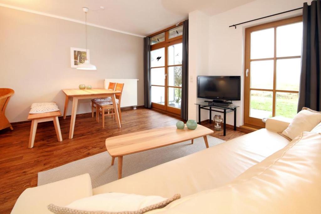 a living room with a white couch and a table at Ferienwohnung Henke in Wittenbeck