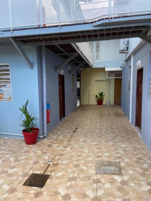 an empty hallway of a building with potted plants at Kayenn’Apparts in Cayenne
