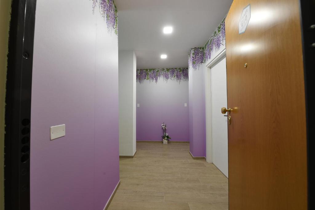 un pasillo con paredes de color púrpura y blanco y una puerta en Le stanze di Gió, en Teramo