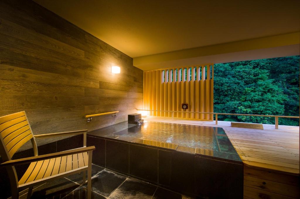 a balcony with a bench and a large window at Hakone Pax Yoshino in Hakone