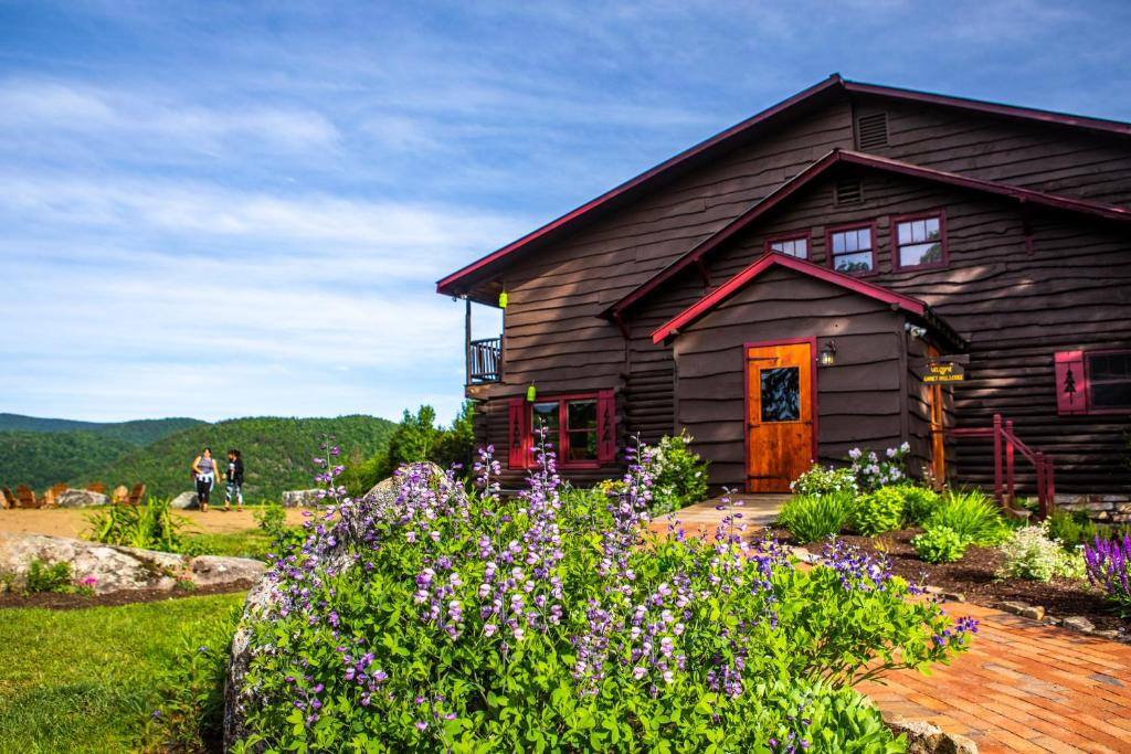 a log cabin with flowers in front of it at Garnet Hill Lodge in North River