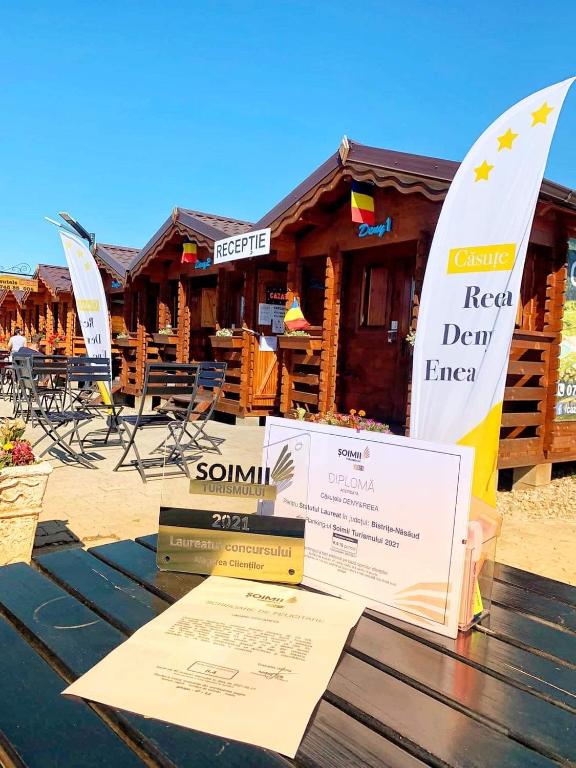 a table with signs on it in front of a resort at Casutele Deny Băile Figa cu aer condiționat in Beclean
