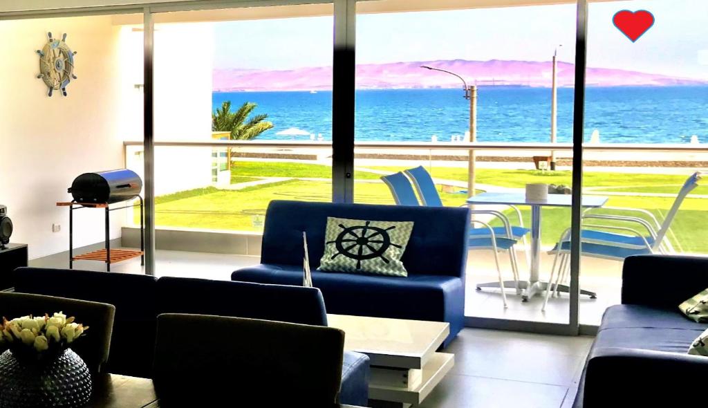 a living room with blue couches and a view of the ocean at Paracas Paracas! Vista Bahia - Sotavento 201 T 6 in Paracas