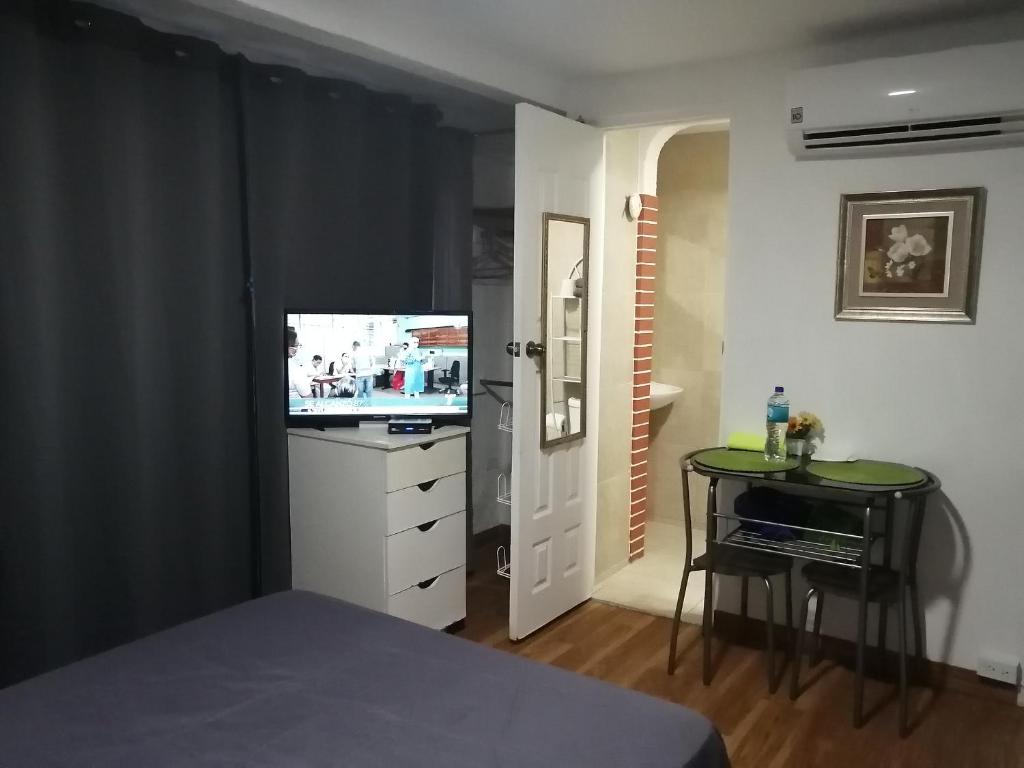 a bedroom with a bed and a television and a table at Anexo independiente y privado totalmente amueblado muy lindo y acogedor in Panama City