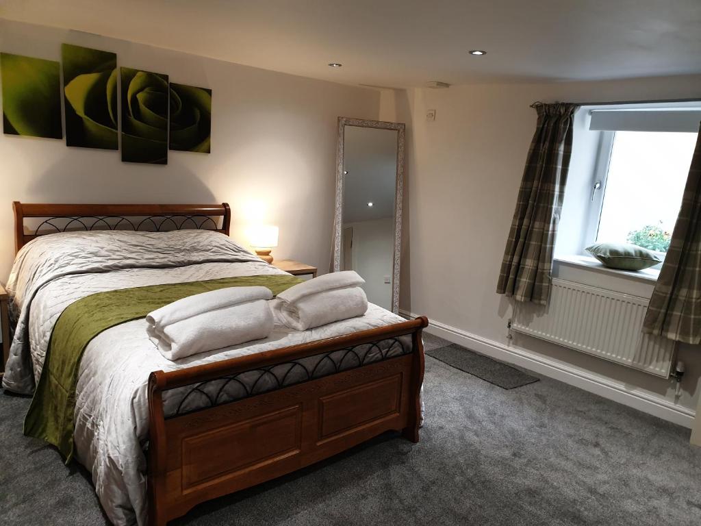 a bedroom with a bed with two pillows on it at Horseshoe Forge Plover Cottage Lindley in Huddersfield