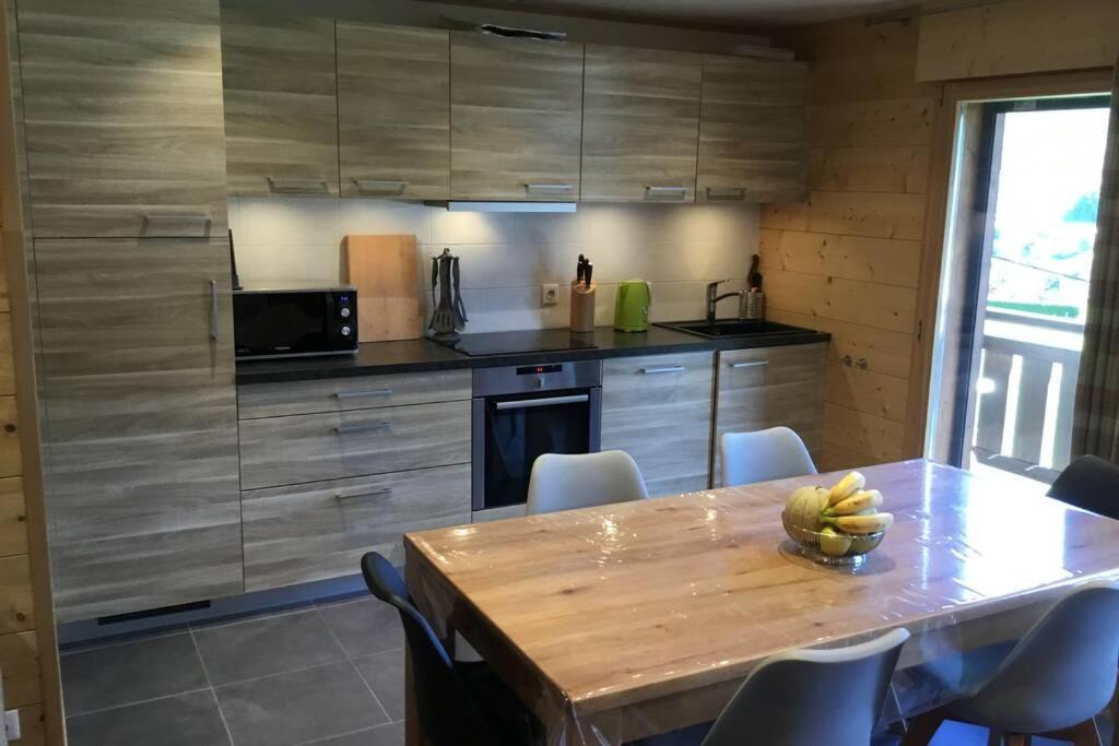 eine Küche mit einem Tisch und einer Schale Bananen drauf in der Unterkunft Modern Comfortable Chalet with large terrace in Morzine