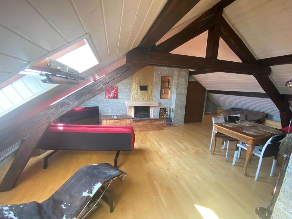 ein Dachzimmer mit einer Treppe, einem Tisch und Stühlen in der Unterkunft Beauregard attique in Lausanne