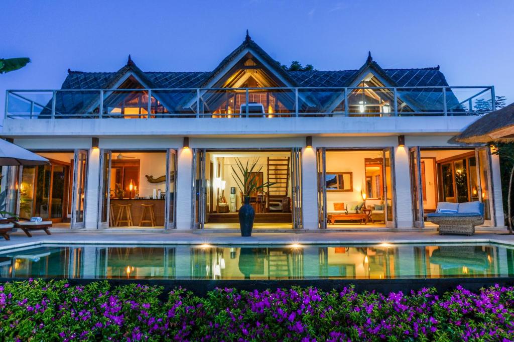 a house with a swimming pool in front of it at Villa Nusa in Nusa Lembongan