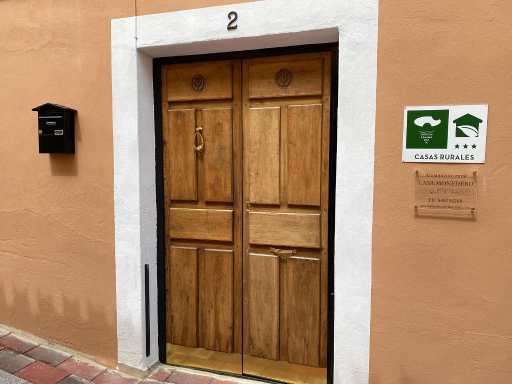 uma porta de madeira na lateral de um edifício em Casa Monedero em La Recueja